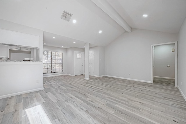 unfurnished living room featuring lofted ceiling with beams and light hardwood / wood-style floors