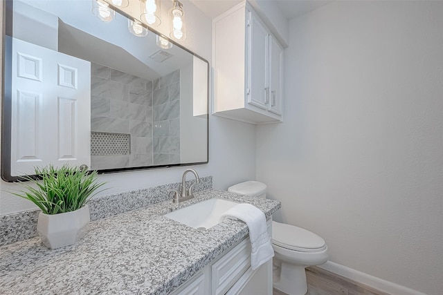 bathroom with vanity, hardwood / wood-style flooring, and toilet