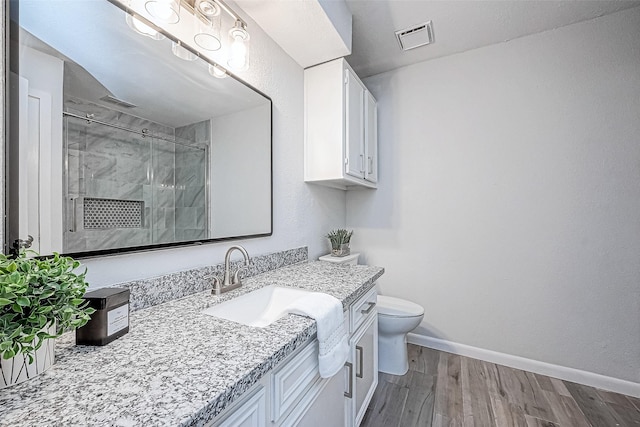 bathroom featuring vanity, toilet, an enclosed shower, and hardwood / wood-style floors