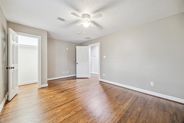 unfurnished bedroom featuring ceiling fan, light hardwood / wood-style flooring, and a textured ceiling