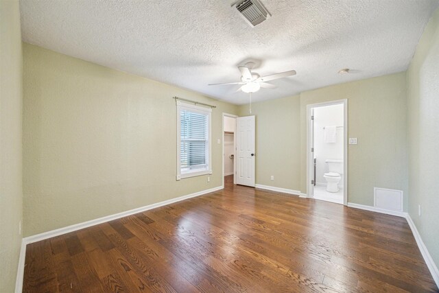 empty room with dark wood-type flooring, a textured ceiling, and ceiling fan