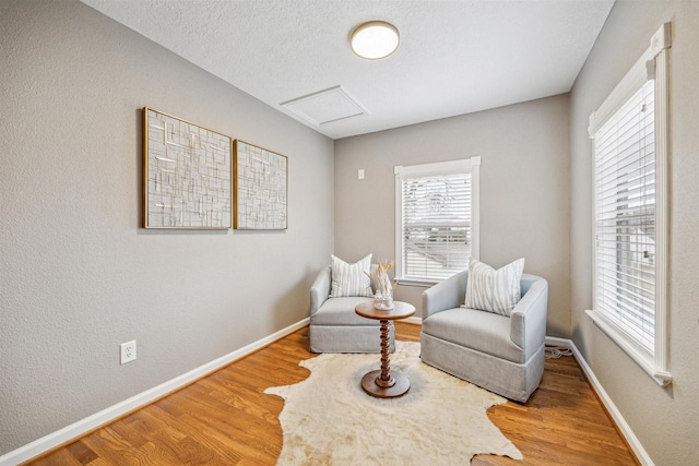 sitting room with hardwood / wood-style floors and a textured ceiling