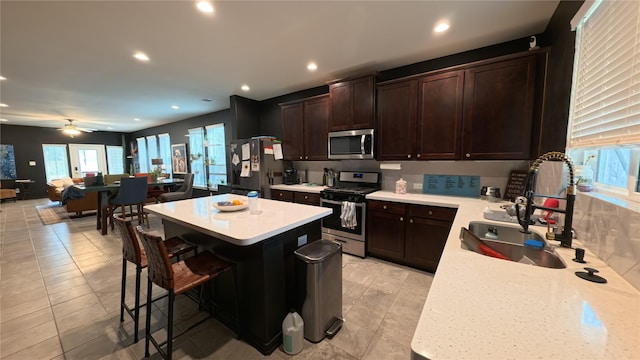 kitchen featuring stainless steel appliances, a center island, sink, and a kitchen breakfast bar