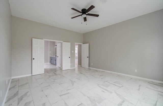 unfurnished bedroom featuring marble finish floor, baseboards, and a ceiling fan