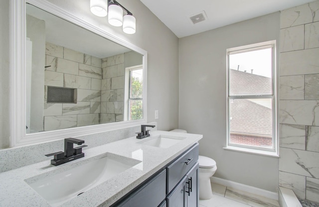 bathroom with a wealth of natural light, visible vents, a sink, and toilet