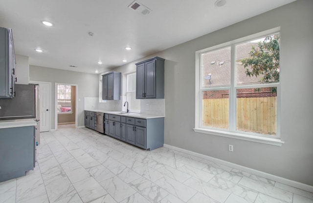 kitchen featuring marble finish floor, tasteful backsplash, light countertops, and baseboards