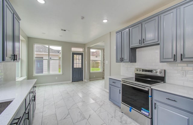 kitchen featuring tasteful backsplash, recessed lighting, marble finish floor, and stainless steel range with electric cooktop