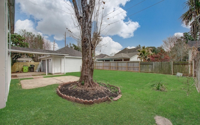 view of yard featuring a patio area, a fenced backyard, and an outbuilding