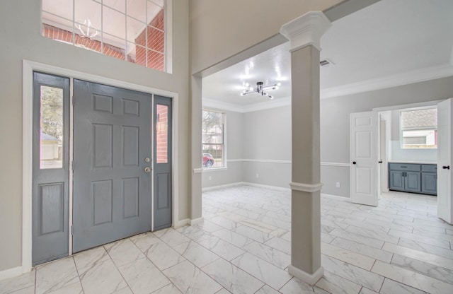 entryway with marble finish floor, baseboards, crown molding, and ornate columns