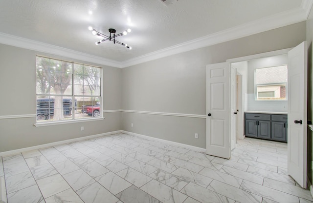 unfurnished room featuring marble finish floor, crown molding, baseboards, and an inviting chandelier