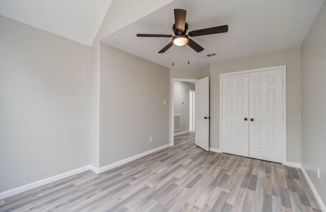 unfurnished bedroom with baseboards, visible vents, a ceiling fan, light wood-style floors, and a closet