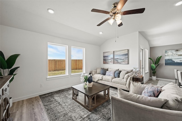 living room featuring vaulted ceiling, dark hardwood / wood-style floors, and ceiling fan