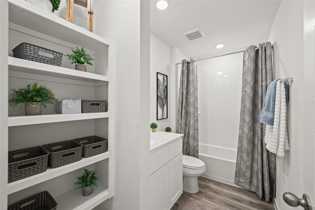 full bathroom with hardwood / wood-style flooring, shower / bathtub combination with curtain, vanity, and toilet