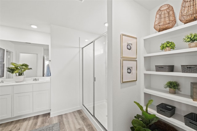 bathroom with a shower with door, wood-type flooring, and vanity