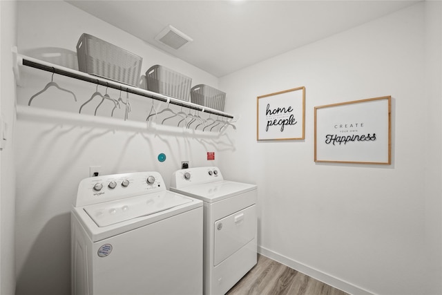 clothes washing area with light hardwood / wood-style floors and independent washer and dryer