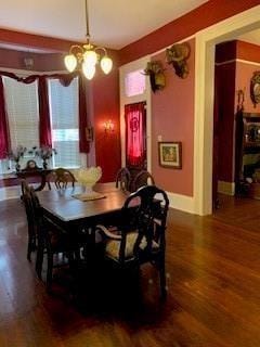 dining room featuring dark wood-type flooring and a chandelier