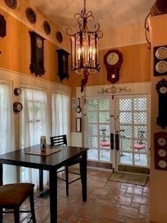 dining area with a high ceiling, a wealth of natural light, a notable chandelier, and french doors