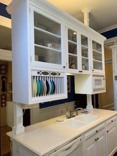 bar with sink, dishwasher, and white cabinets