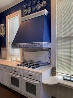 kitchen featuring backsplash, gas cooktop, oven, and white cabinets