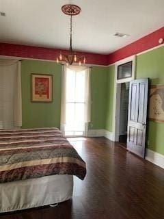 bedroom with wood-type flooring and a chandelier