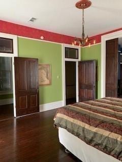 bedroom with hardwood / wood-style floors and a chandelier