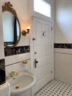 bathroom with sink and tile walls