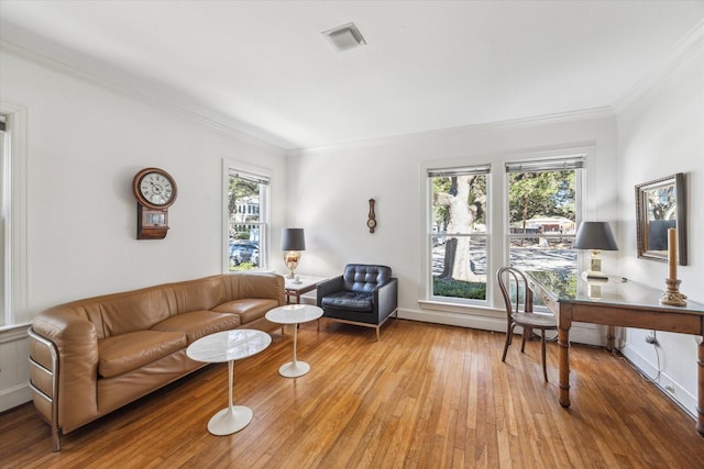 living room with crown molding and light hardwood / wood-style flooring