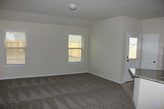 interior space with light carpet, plenty of natural light, and baseboards