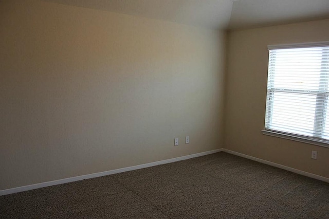 unfurnished room with carpet floors and baseboards