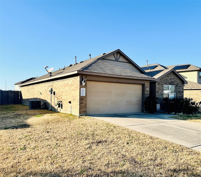 view of front of home with brick siding, central air condition unit, a garage, driveway, and a front lawn