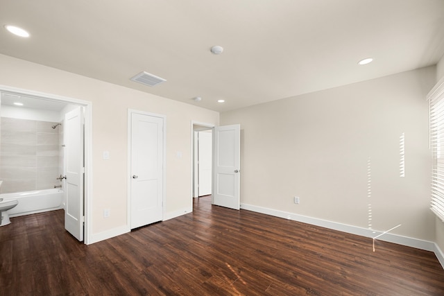 unfurnished bedroom with dark wood-type flooring and ensuite bathroom