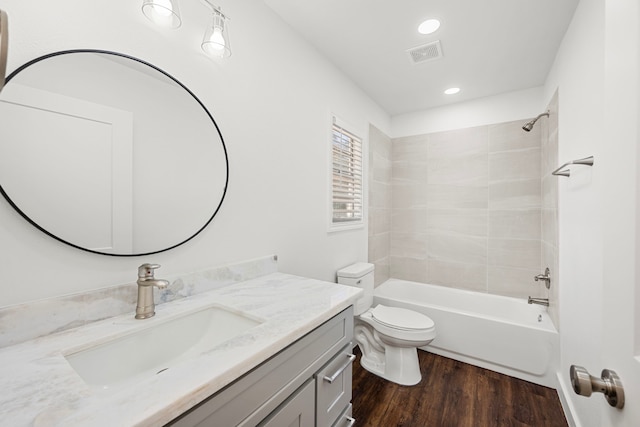 full bathroom featuring tiled shower / bath, wood-type flooring, toilet, and vanity