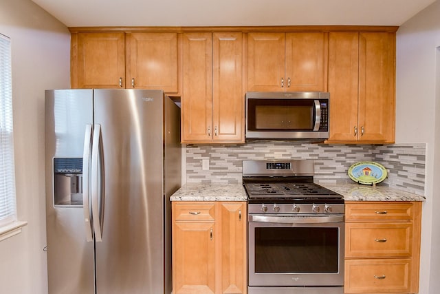 kitchen with decorative backsplash, light stone countertops, and appliances with stainless steel finishes