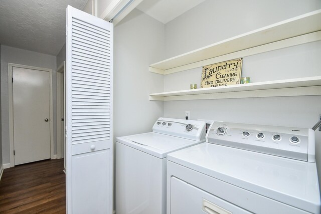 washroom featuring dark hardwood / wood-style floors, washer and dryer, and a textured ceiling