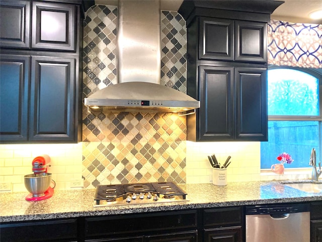 kitchen with a sink, wall chimney range hood, tasteful backsplash, and stainless steel appliances