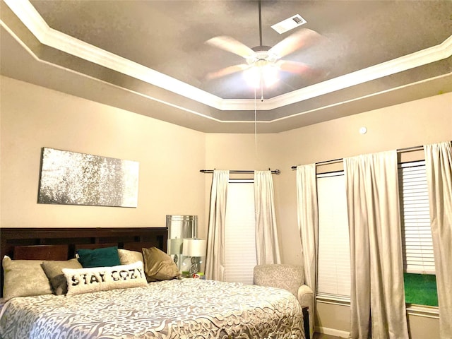 bedroom with visible vents, a raised ceiling, and ceiling fan