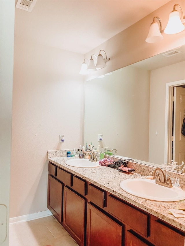 bathroom with double vanity, visible vents, and a sink