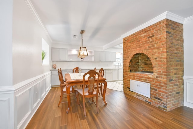 dining space with dark hardwood / wood-style flooring, sink, and crown molding