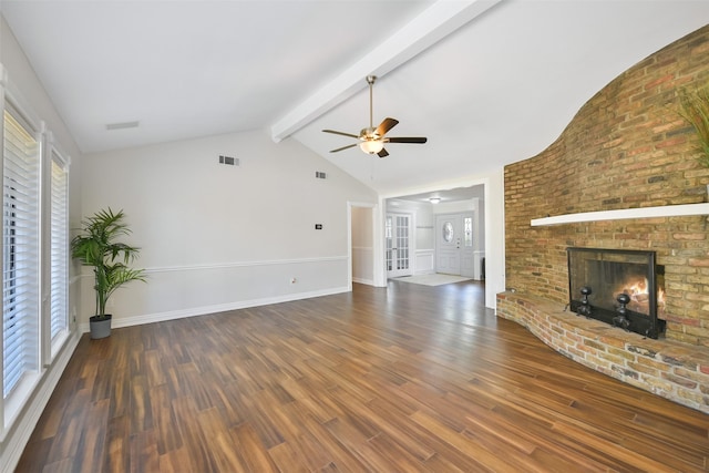 unfurnished living room featuring ceiling fan, a brick fireplace, vaulted ceiling with beams, and dark hardwood / wood-style floors