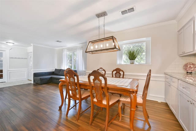 dining room featuring ornamental molding and dark wood-type flooring