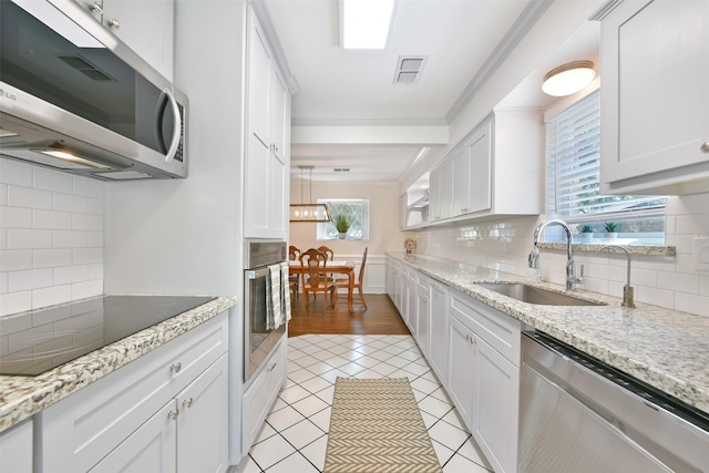 kitchen featuring white cabinetry, appliances with stainless steel finishes, sink, and light tile patterned floors