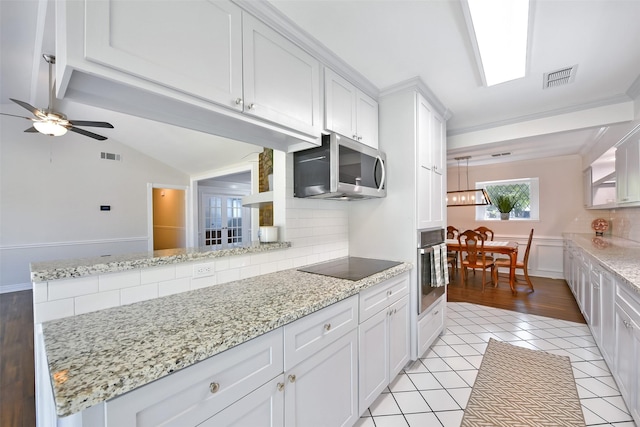 kitchen with stainless steel appliances, white cabinetry, tasteful backsplash, and light tile patterned floors