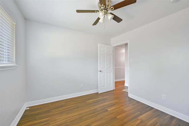 unfurnished room with ceiling fan and dark hardwood / wood-style flooring