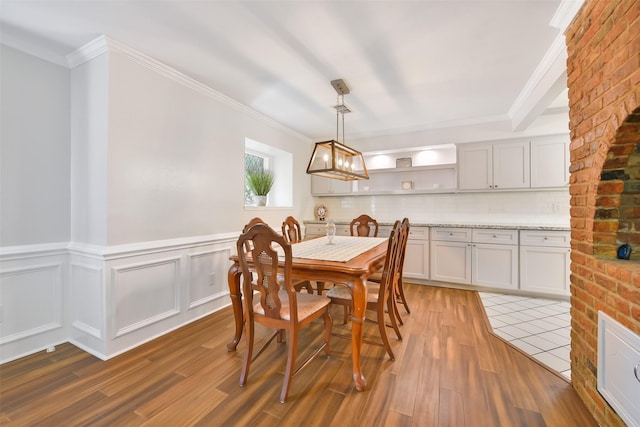 dining area featuring dark wood-type flooring and ornamental molding