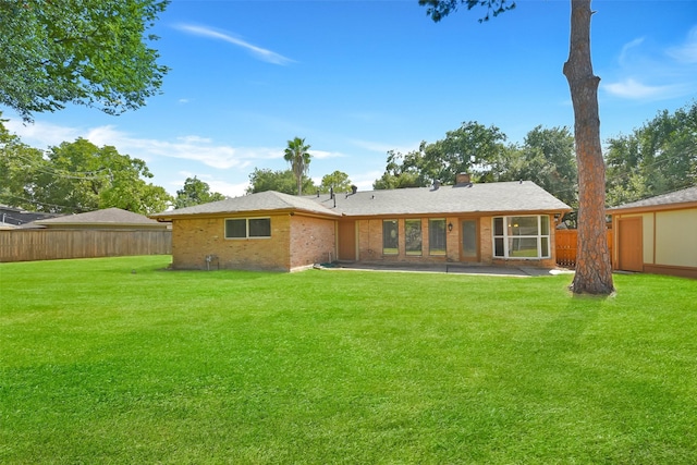 rear view of house with a yard and a patio area