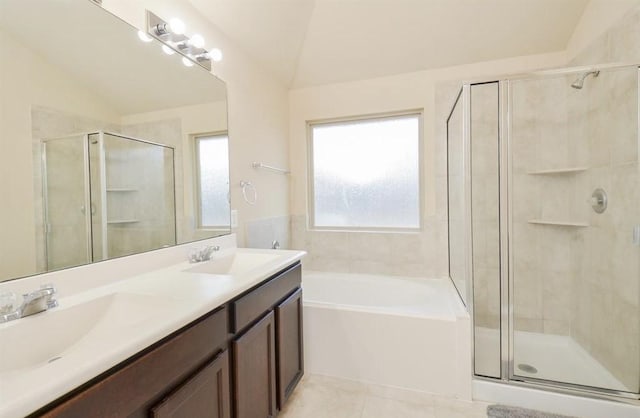 bathroom featuring tile patterned floors, shower with separate bathtub, vaulted ceiling, and vanity