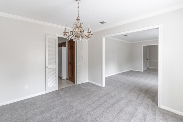 carpeted spare room featuring a notable chandelier and ornamental molding