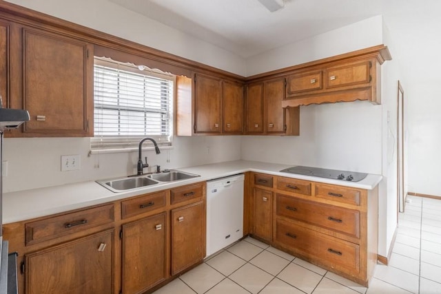 kitchen featuring black electric cooktop, sink, light tile patterned floors, and white dishwasher