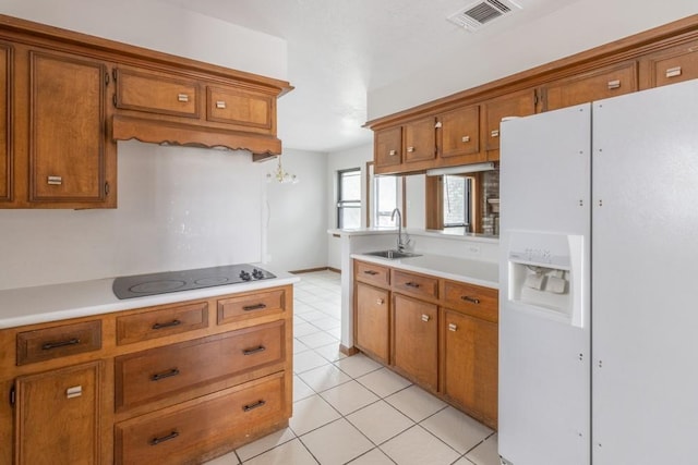 kitchen featuring white refrigerator with ice dispenser, sink, light tile patterned floors, and black electric cooktop