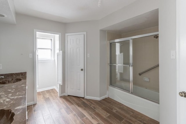 bathroom featuring vanity, wood-type flooring, and enclosed tub / shower combo